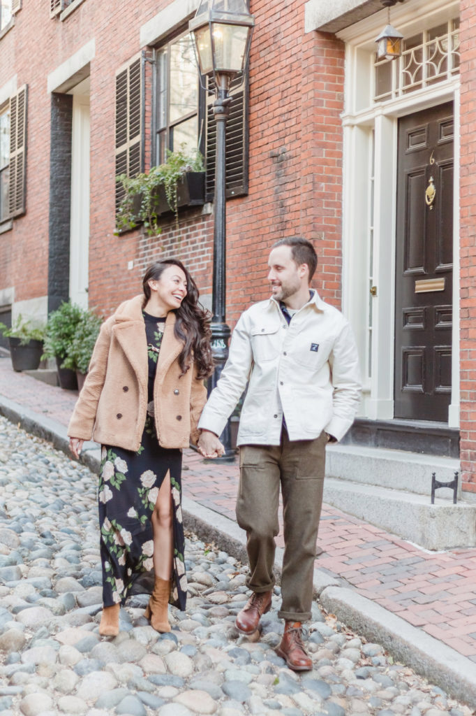 engaged couple walks hand in hand down Acorn Street in Beacon Hill