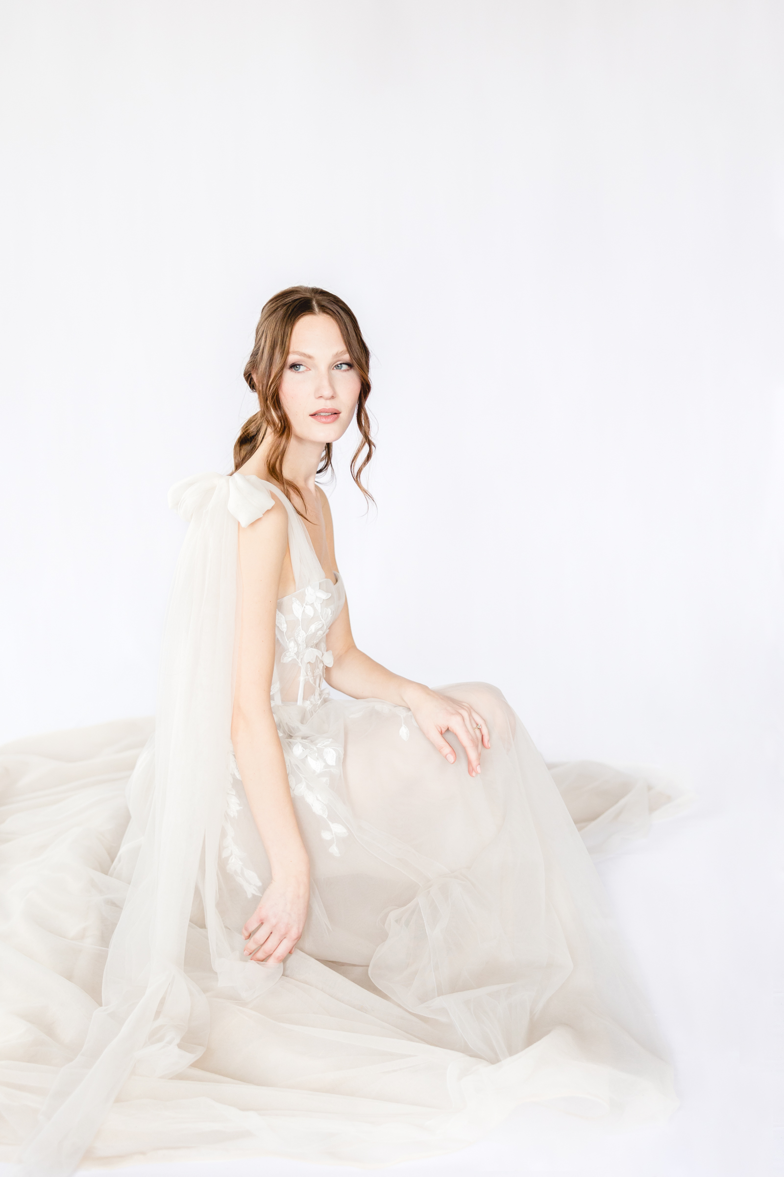 Ethereal bride sitting in a soft flowy wedding dress.