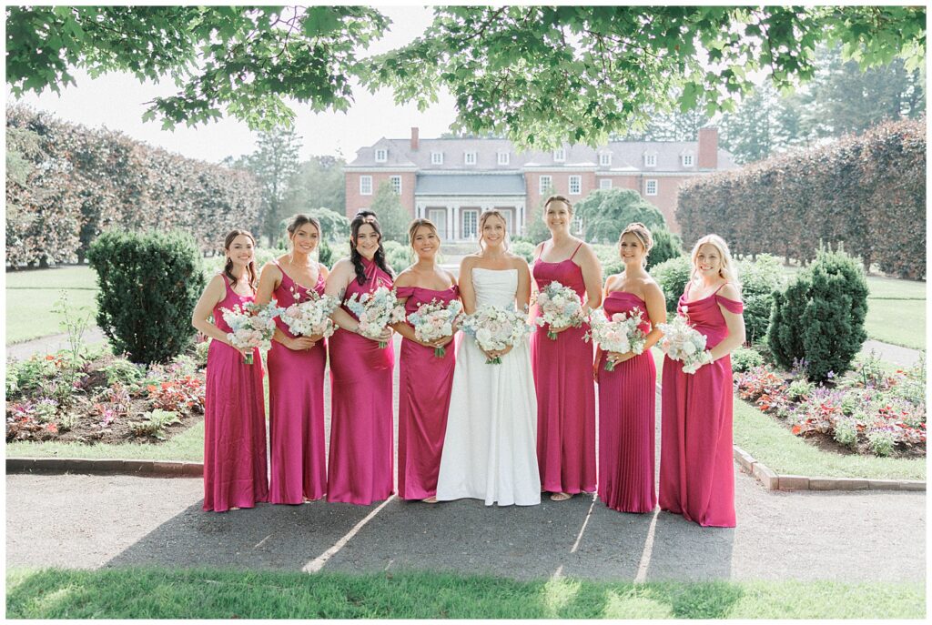 Bridal party in fuchsia silk dresses from Revelry at the Gardens at Elm Bank.
